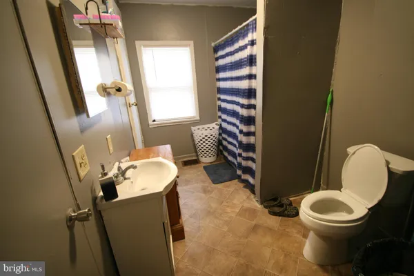 a bathroom with a toilet a sink and a mirror