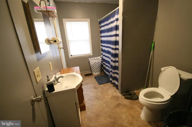 a bathroom with a toilet a sink and a mirror
