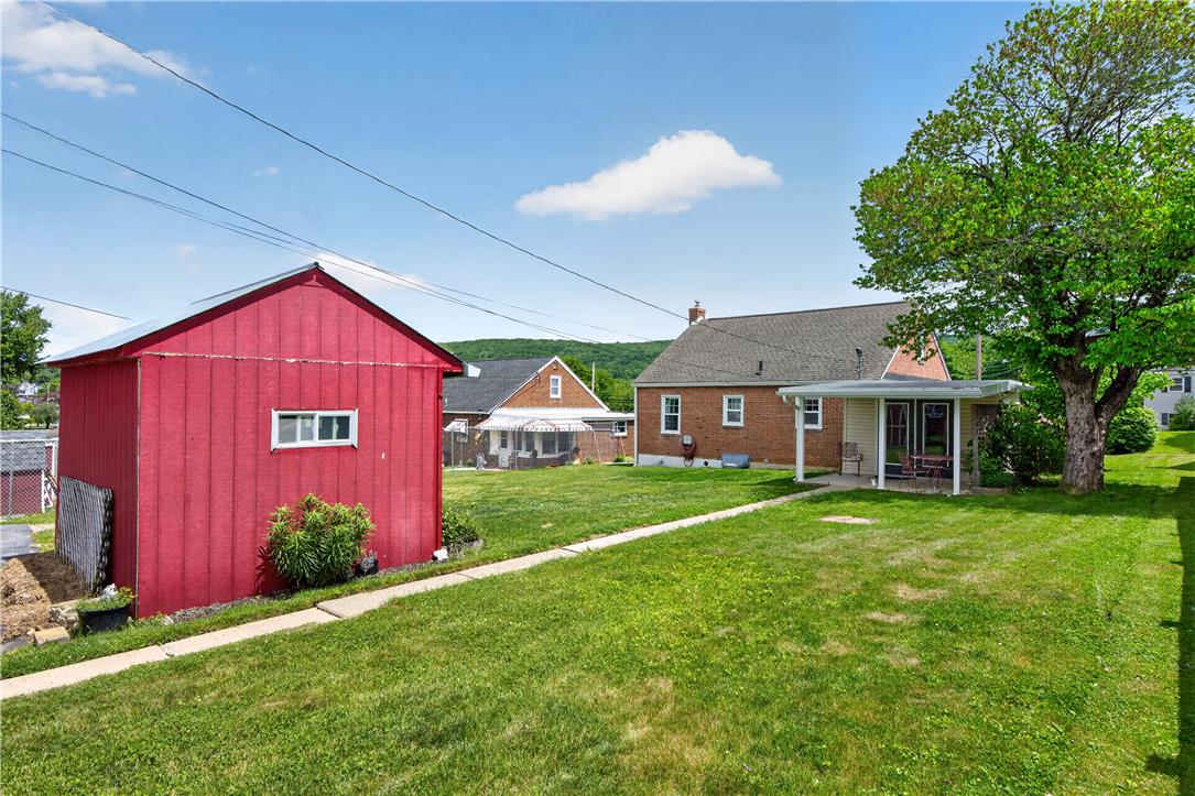 23 Harrison Street Emmaus, PA 18049 - Photo 15 of 28 A spacious yard offers ample outdoor living, featuring a vibrant red outbuilding and a charming covered patio.