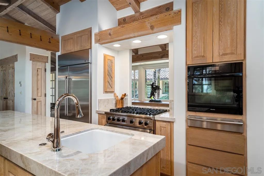 6146 Paseo Valencia Rancho Santa Fe, CA 92067 - Photo 9 of 25 a kitchen with granite countertop a sink and a stove top oven
