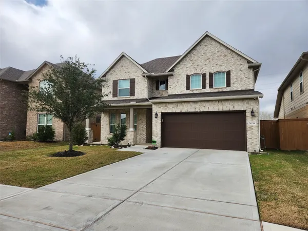 a front view of a house with yard and parking