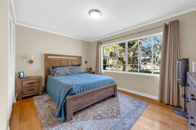 a bedroom with a bed and wooden floor