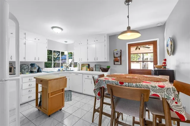 a open kitchen with a table chairs and white cabinets