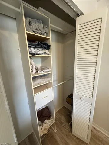 a room with a walk in closet and wooden floor
