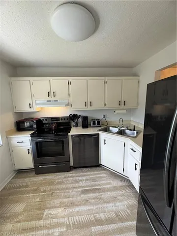 a kitchen with a stove sink and a refrigerator