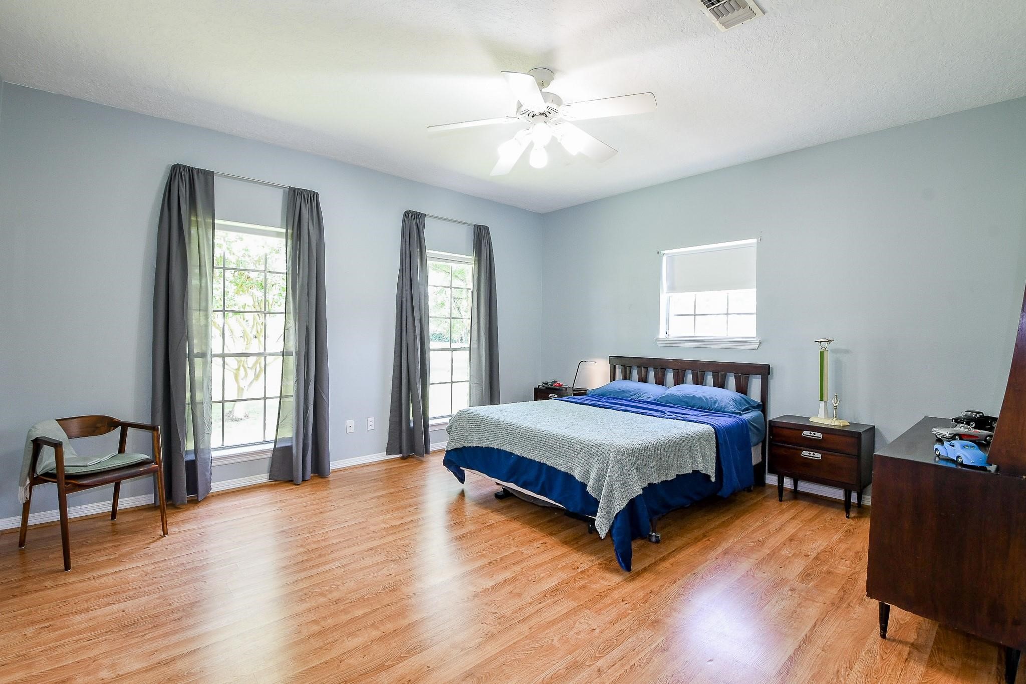 22035 Buescher Road Tomball, TX 77377 - Photo 24 of 43 a spacious bedroom with a bed and a chandelier