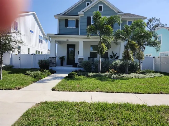 a front view of a house with a yard and potted plants