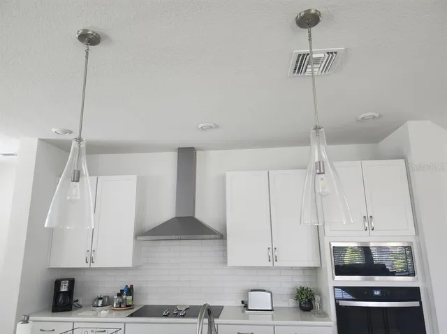 a kitchen with stainless steel appliances granite countertop a sink a stove and a refrigerator