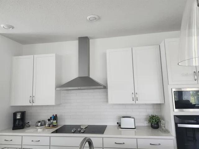 a kitchen with stainless steel appliances white cabinets and a sink