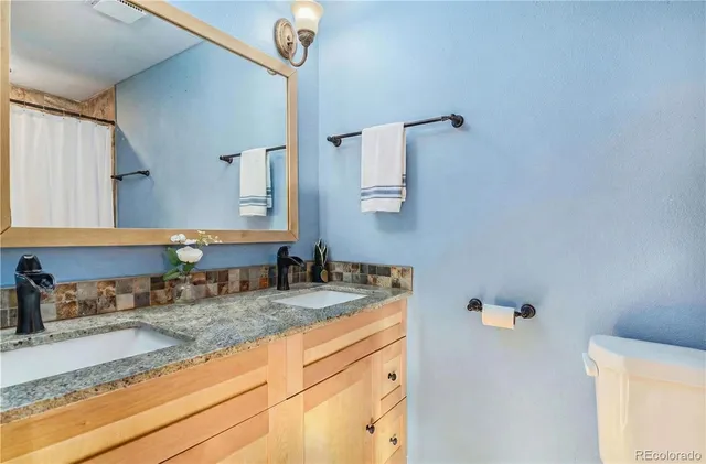 a bathroom with a granite countertop sink a mirror and shower