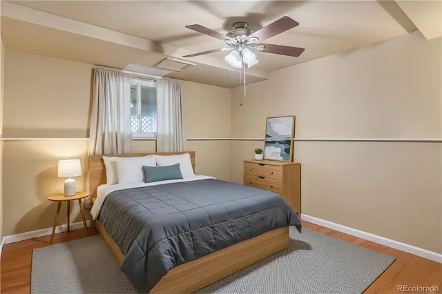 a bedroom with a bed a lamp on the dresser and a chandelier