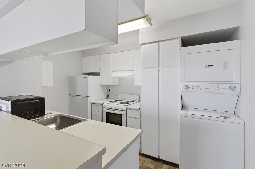 2221 West Bonanza Road, Unit 28 Las Vegas, NV 89106 - Photo 10 of 15 This compact kitchen offers essential appliances and efficient laundry facilities for convenient living.