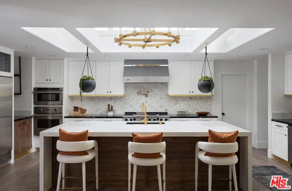 a kitchen with stainless steel appliances granite countertop a table and chairs in it