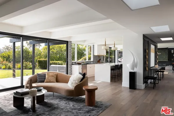 a living room with fireplace furniture and a large window