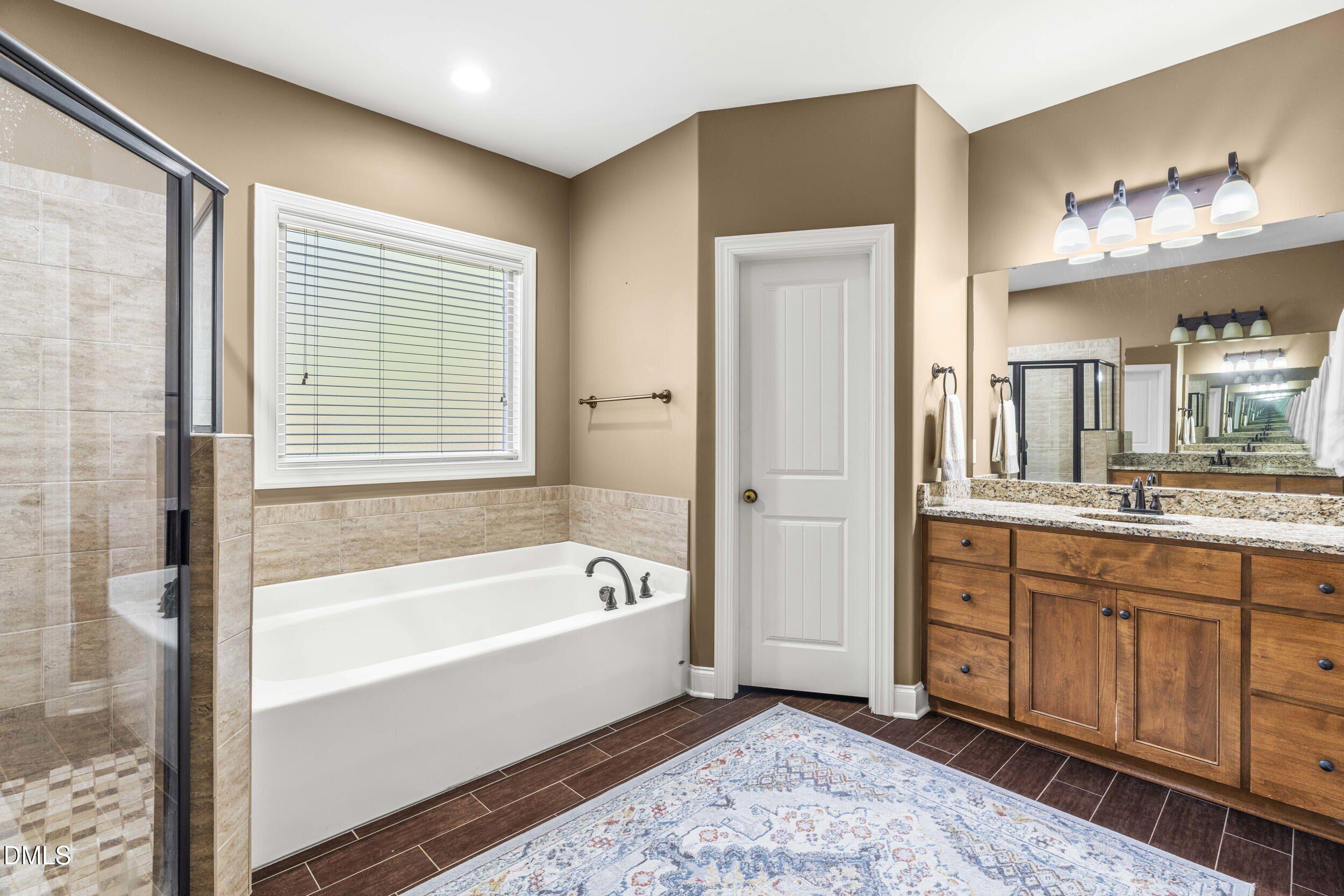 648 Fieldtrial Circle Garner, NC 27529 - Photo 25 of 56 a spacious bathroom with a tub sink and mirror