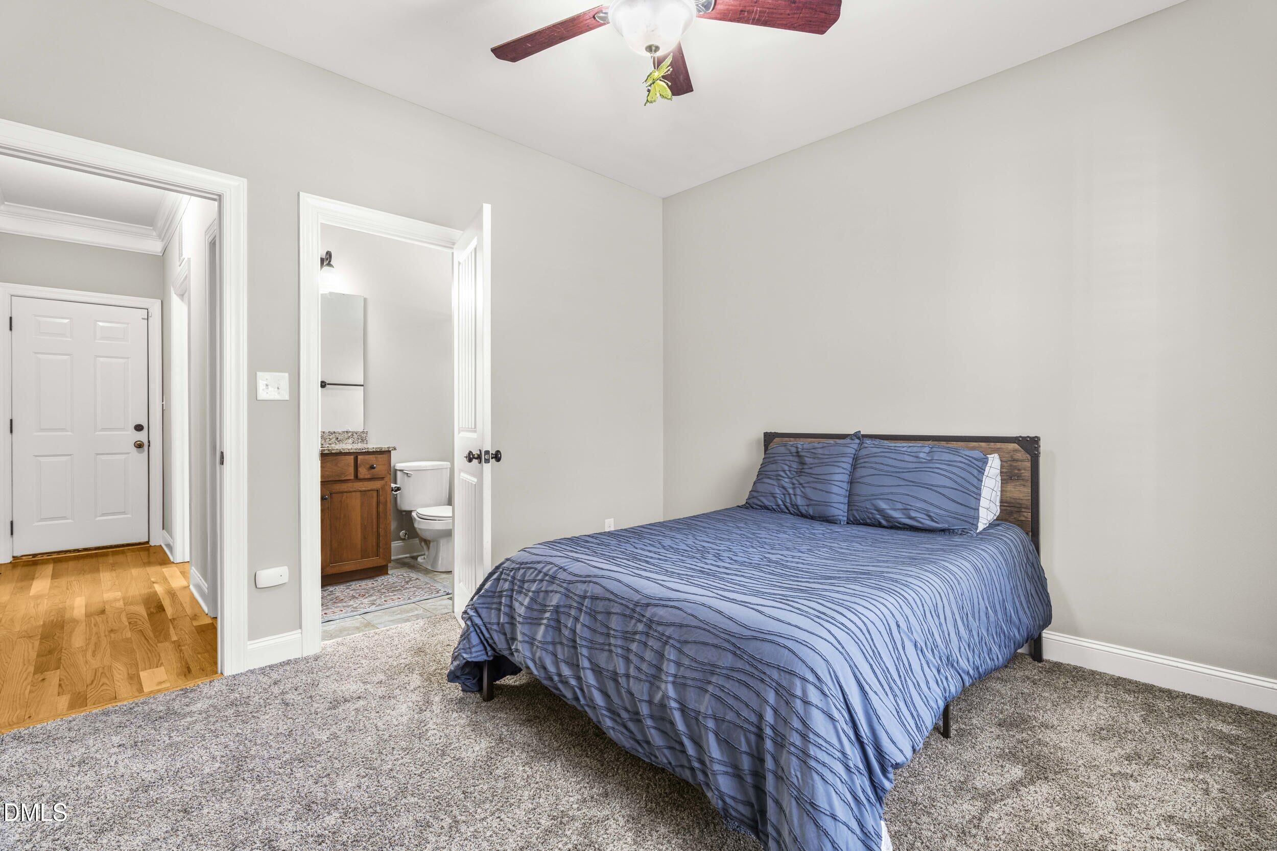 648 Fieldtrial Circle Garner, NC 27529 - Photo 29 of 56 a bedroom with a bed and a chandelier