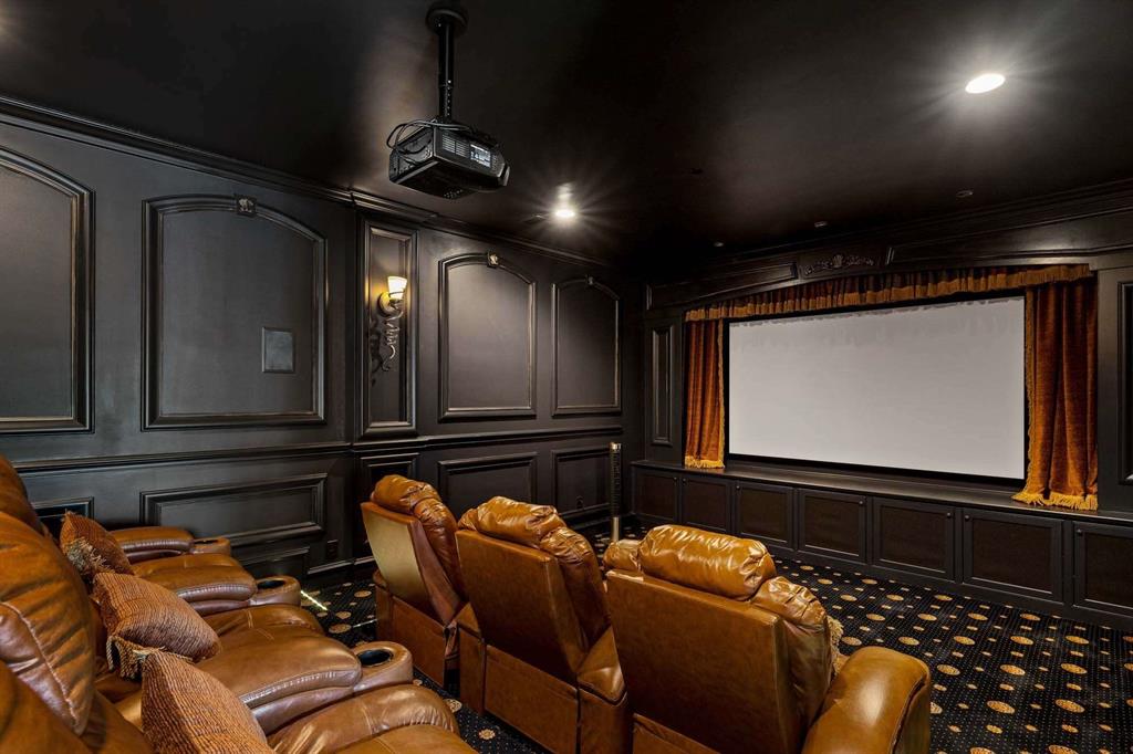 2115 Paradise Rnch Trail McKinney, TX 75071 - Photo 22 of 40 Dedicated home theater featuring a large projection screen, recessed lighting, wall sconces, and extensive wainscoting