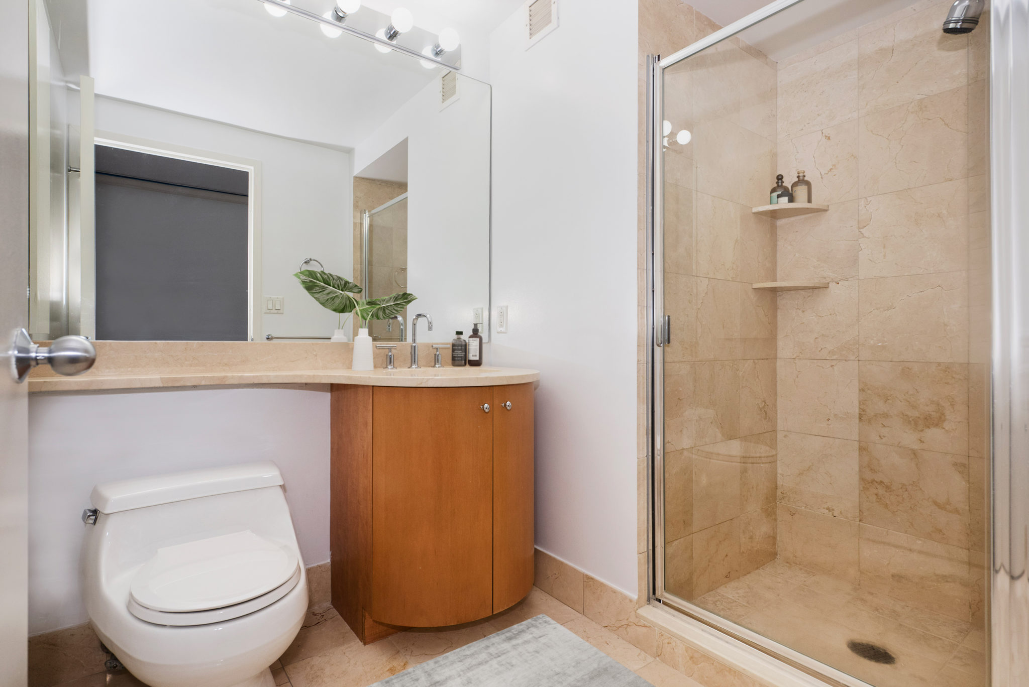 a bathroom with a granite countertop sink toilet and shower