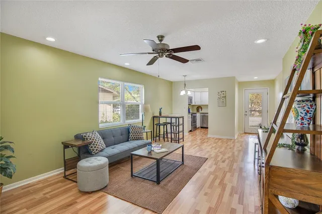 a living room with furniture and a wooden floor