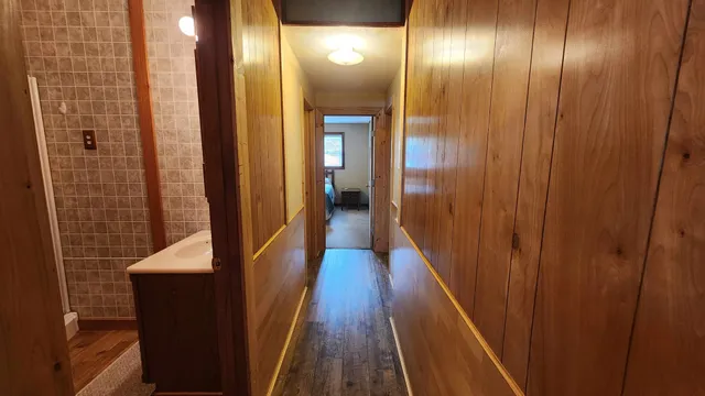 a view of a hallway with wooden floor
