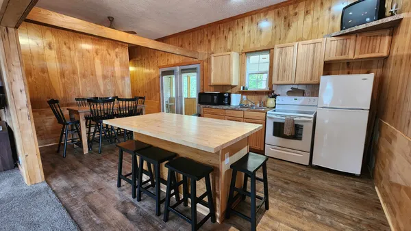 a kitchen with stainless steel appliances a table chairs and a refrigerator