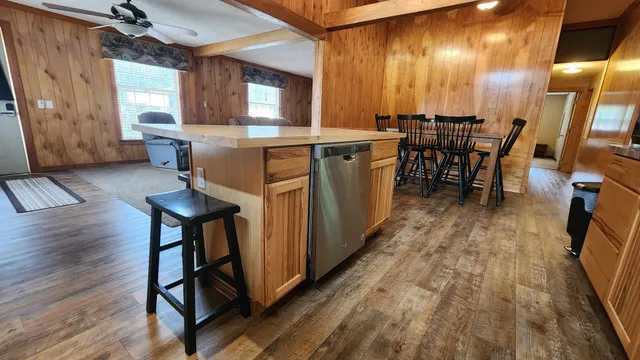 a dining hall with stainless steel appliances granite countertop a stove oven a dining table and chairs with wooden floor