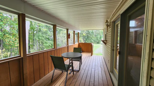 a view of a porch with furniture and wooden floor