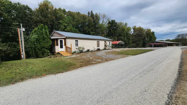 a view of a house with backyard and trees