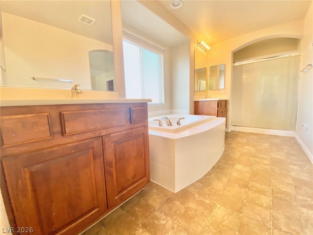 8569 Rhamus Court Las Vegas, NV 89149 - Photo 29 of 35 Relax in the deep soaking tub of this naturally illuminated bathroom with dual vanities and a spacious shower.