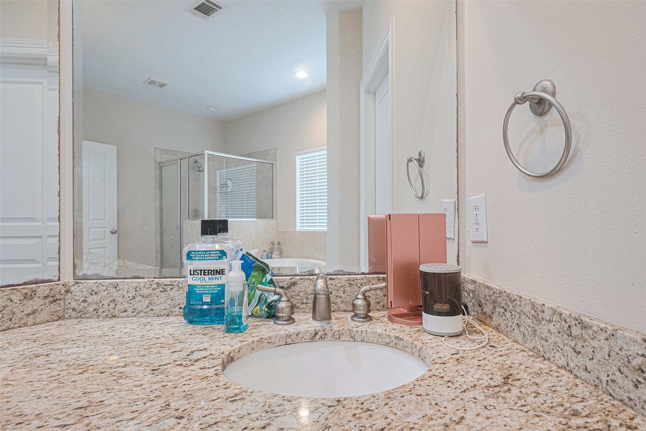24 Versante Court Houston, TX 77070 - Photo 16 of 30 a bathroom with a granite countertop sink a mirror and a vanity