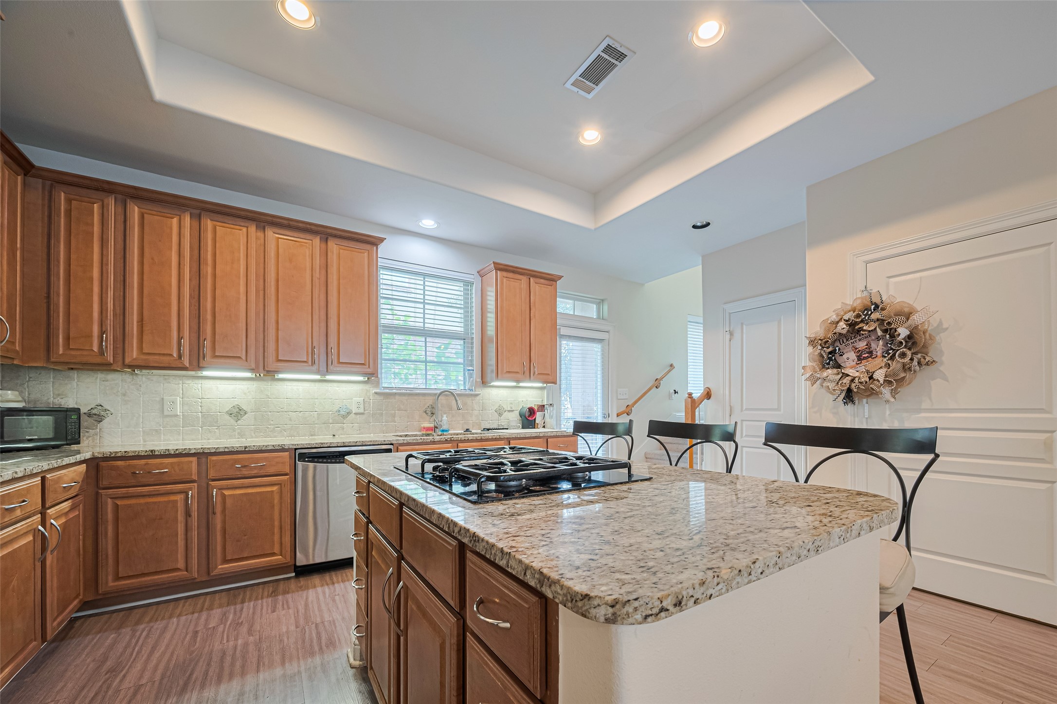 24 Versante Court Houston, TX 77070 - Photo 27 of 30 a kitchen with stainless steel appliances granite countertop a stove a sink dishwasher and cabinets with wooden floor