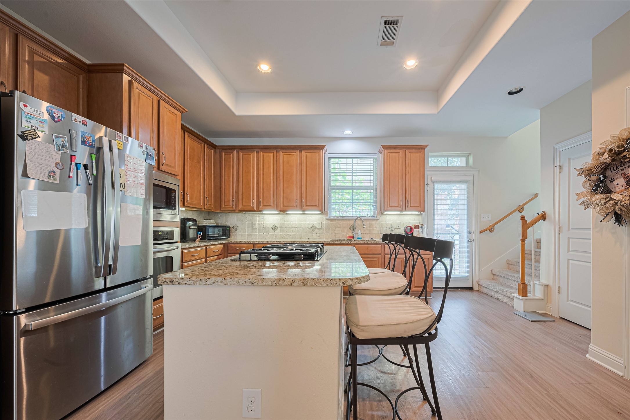 24 Versante Court Houston, TX 77070 - Photo 29 of 30 a kitchen with stainless steel appliances granite countertop a refrigerator a stove a sink dishwasher and white cabinets with wooden floor