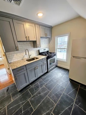 a kitchen with a sink a stove and cabinets