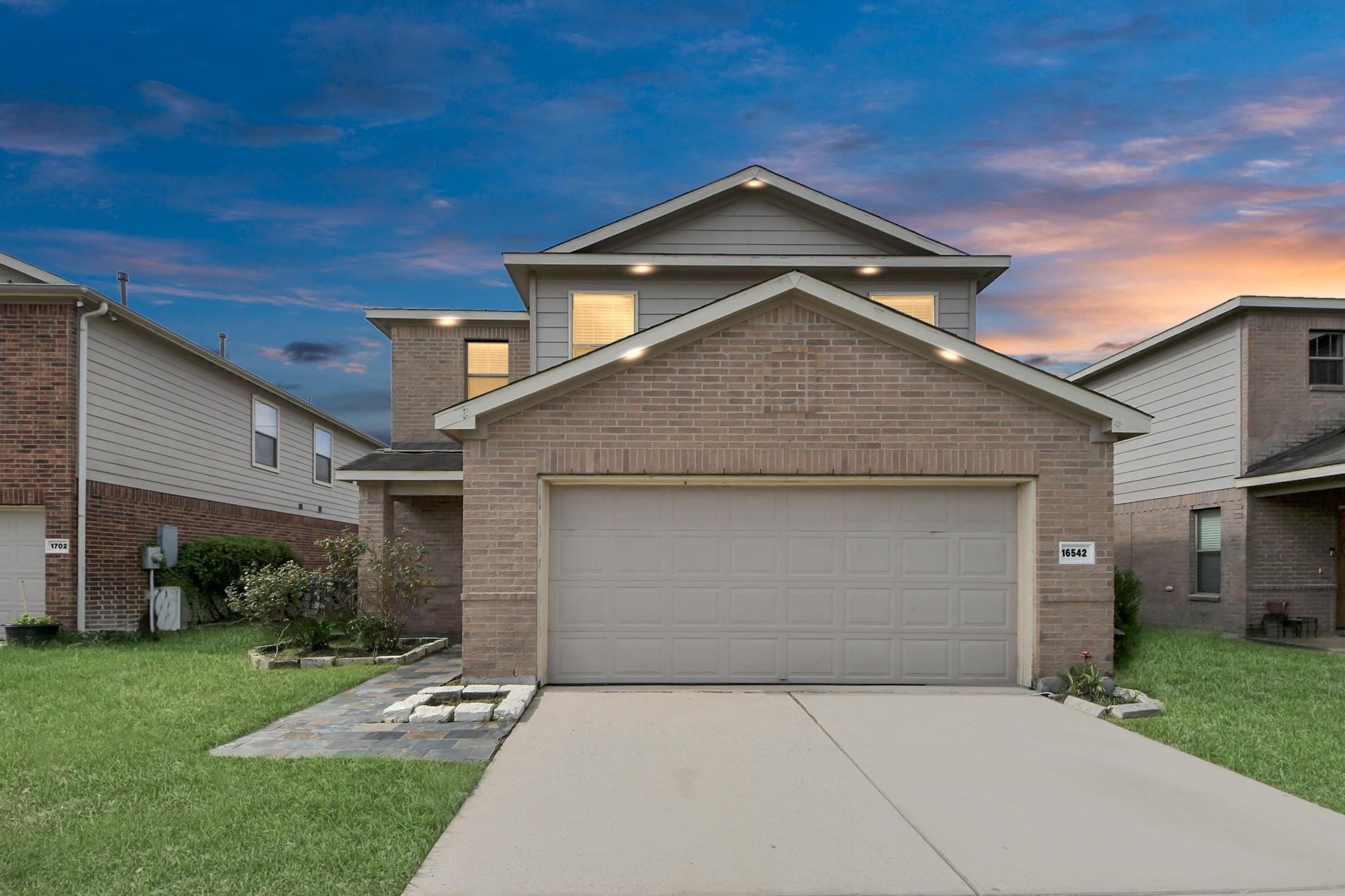 a front view of a house with a yard and garage