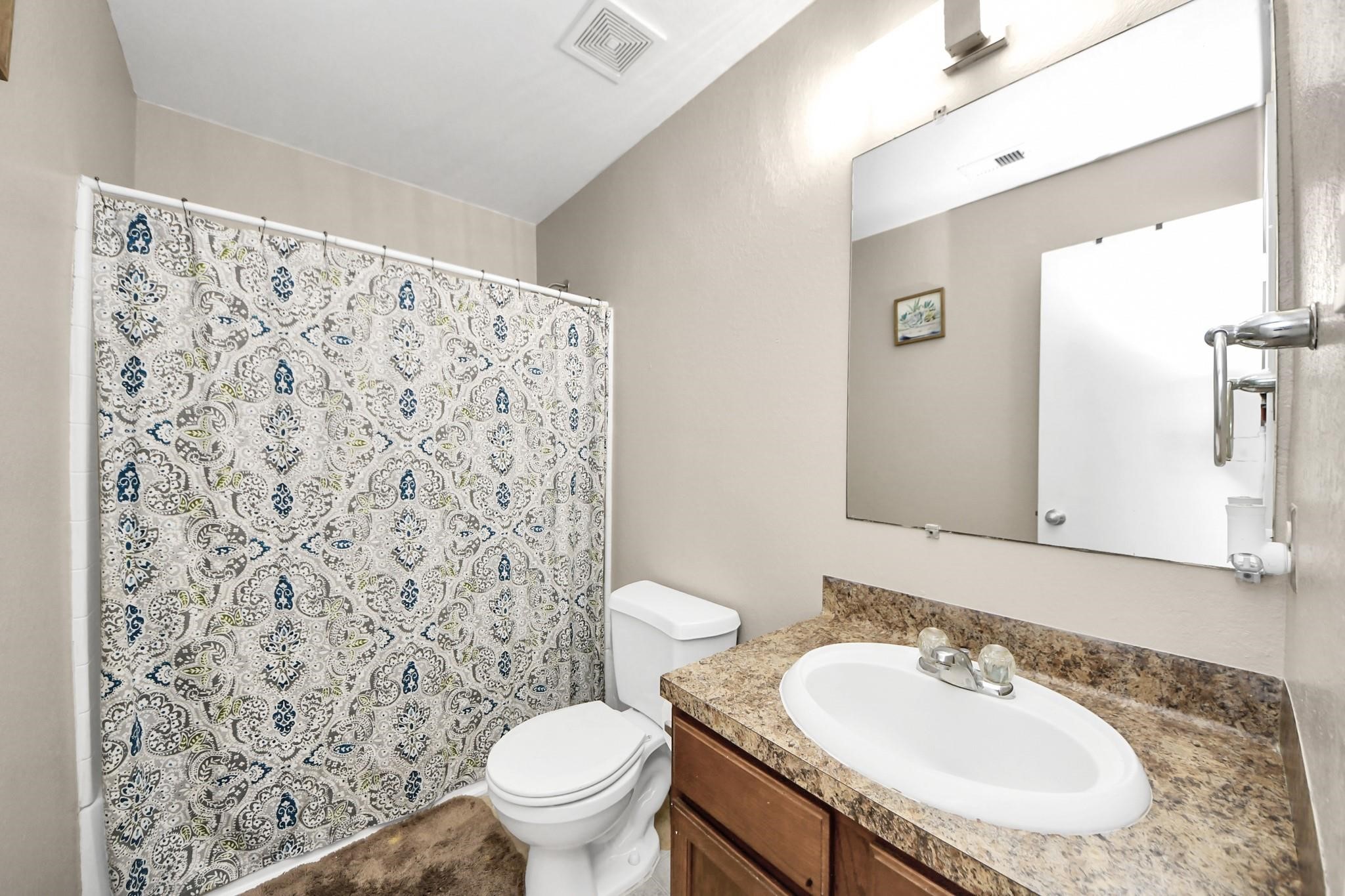 16542 Peyton Ridge Circle Houston, TX 77049 - Photo 13 of 16 a bathroom with a granite countertop sink toilet and a mirror