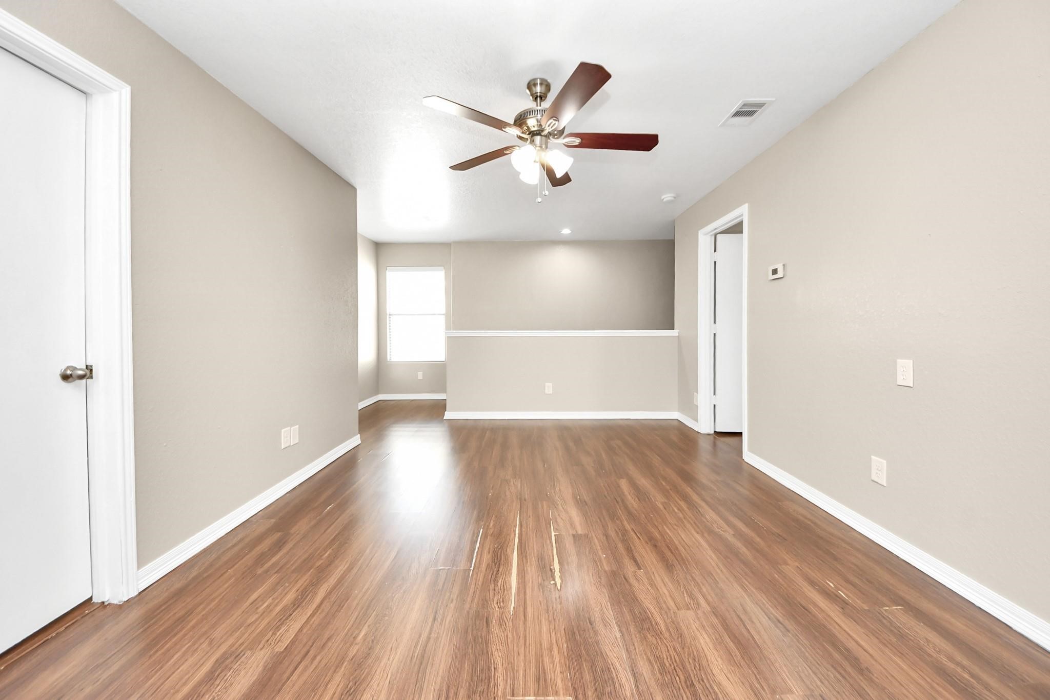 16542 Peyton Ridge Circle Houston, TX 77049 - Photo 14 of 16 a view of an empty room with wooden floor and a window