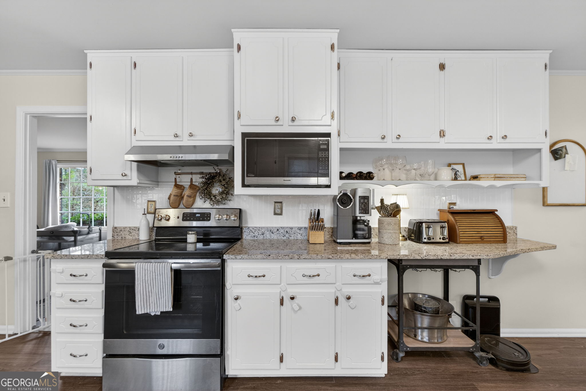 209 Laramie Road Griffin, GA 30224 - Photo 13 of 36 a kitchen with stainless steel appliances granite countertop a stove a sink and a white cabinets
