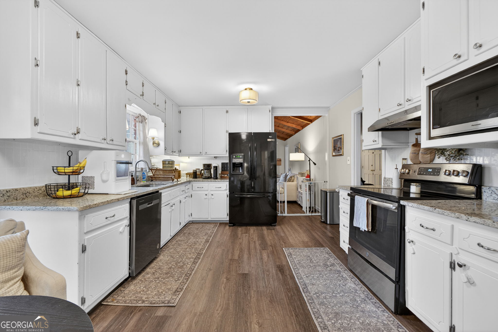 209 Laramie Road Griffin, GA 30224 - Photo 2 of 36 a kitchen with stainless steel appliances granite countertop a stove a sink and white cabinets