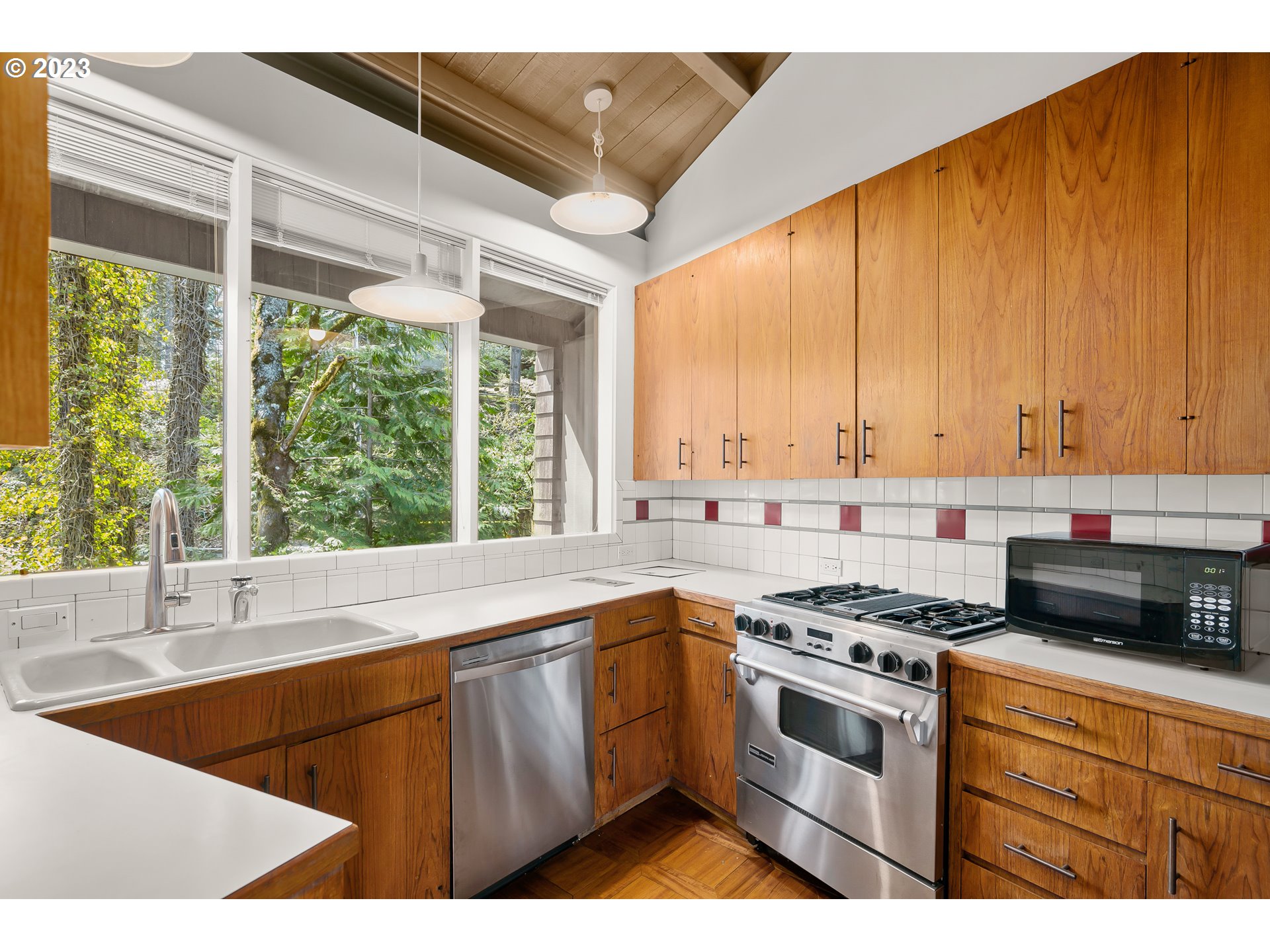 2880 Southwest Fairmount Boulevard Portland, OR 97239 - Photo 13 of 24 a kitchen with stainless steel appliances kitchen island granite countertop a sink a stove a counter top space and cabinets