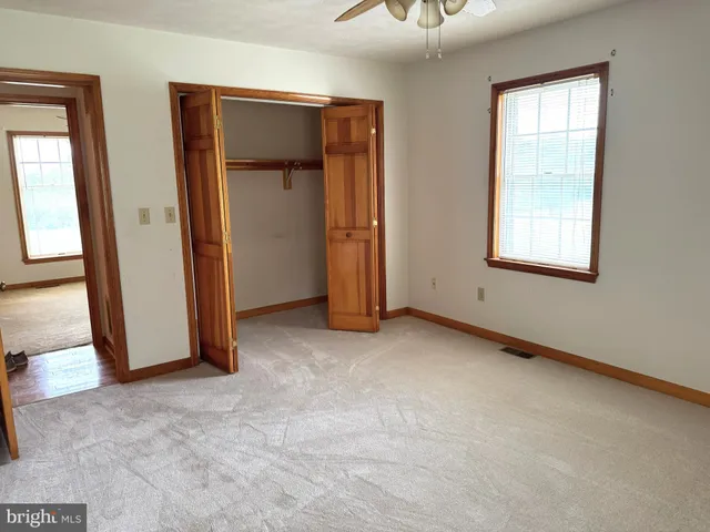 an empty room with windows and closet