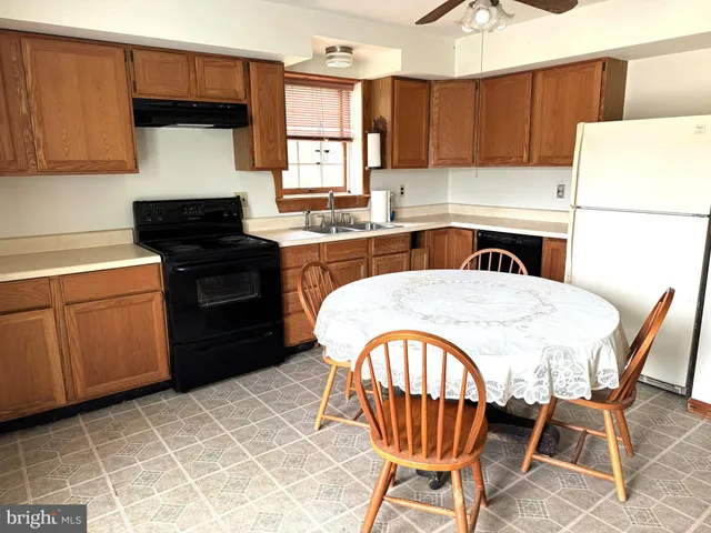 a kitchen with stainless steel appliances a stove a sink a microwave a refrigerator and cabinets