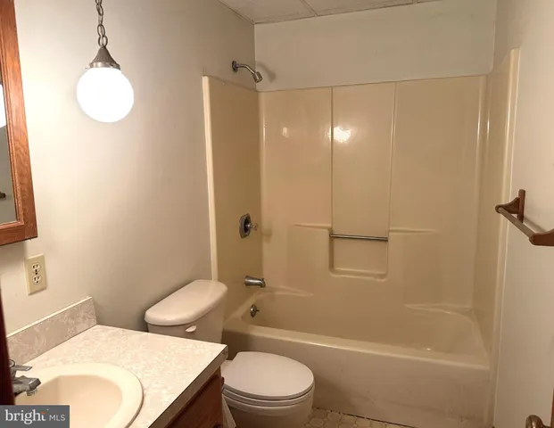 a white toilet sitting next to a bath tub