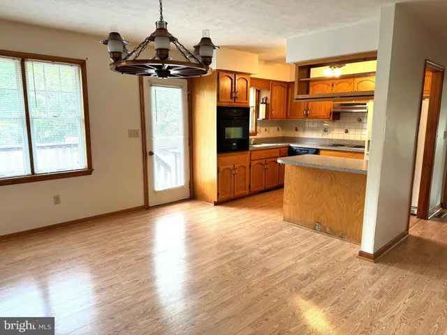 a kitchen with stainless steel appliances granite countertop a refrigerator a oven a sink with wooden floors and cabinets