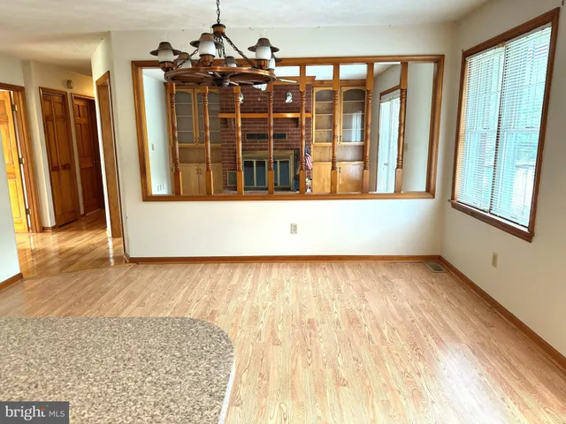 view of an empty room with wooden floor and a window