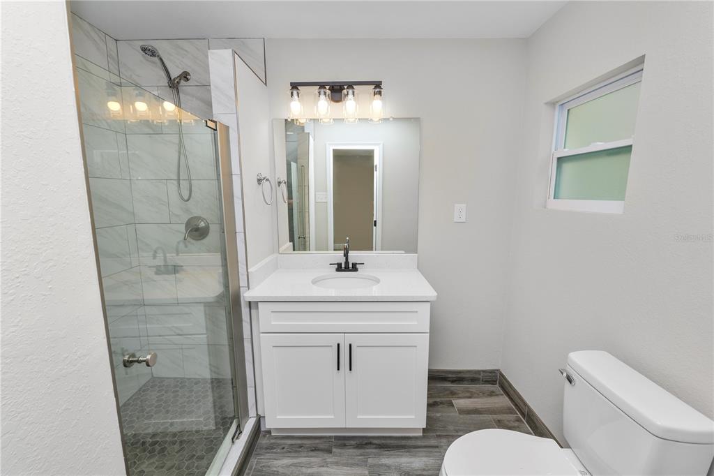 5105 Hayes Road Lakeland, FL 33811 - Photo 22 of 43 a bathroom with a granite countertop sink toilet a mirror and shower