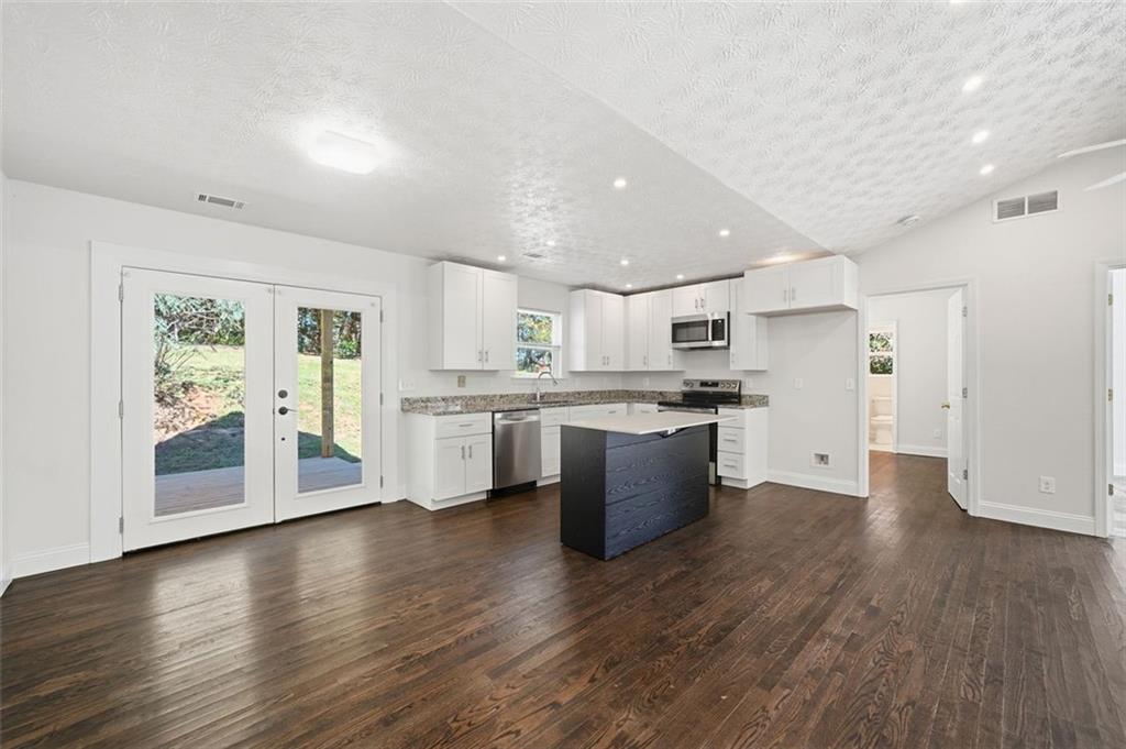 1512 Upper Sassafras Road Jasper, GA 30143 - Photo 13 of 35 a large kitchen with stainless steel appliances granite countertop a large counter top a stove and a wooden floors