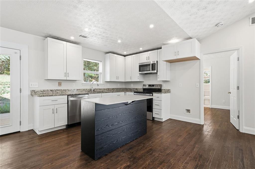 1512 Upper Sassafras Road Jasper, GA 30143 - Photo 14 of 35 a kitchen with granite countertop white cabinets and white appliances