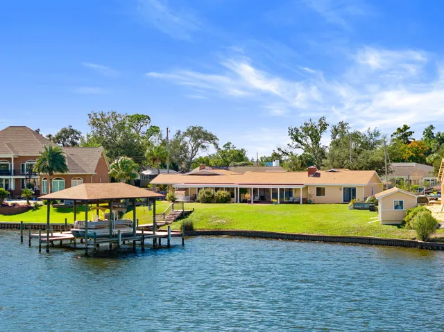 a view of a swimming pool with lawn chairs under an umbrella