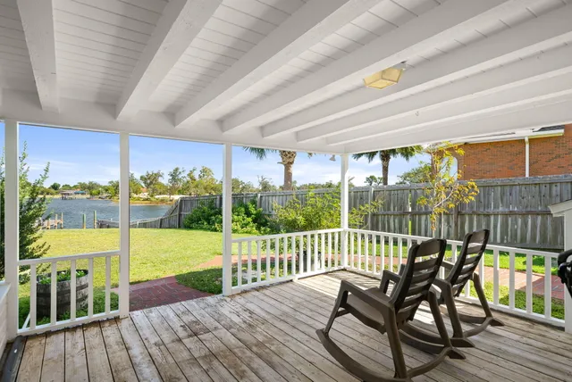 a view of a ocean from a balcony with outdoor seating