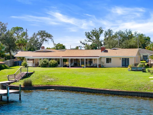 an aerial view of a city with lots of residential buildings ocean and mountain view in back